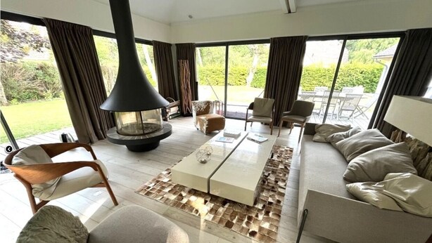 A spacious living room with a large sofa, a coffee table, and a fireplace.