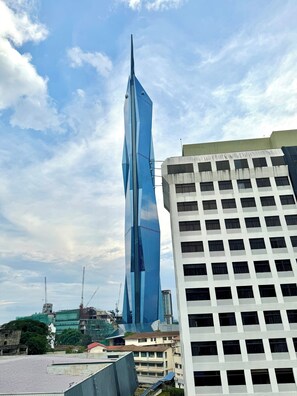 Un rascacielos moderno con un diseño retorcido distintivo, rodeado de otros edificios.