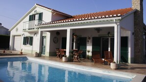 A two-story house with a swimming pool, a balcony, and a patio with outdoor furniture. - Casa Delbon (Aljezur)