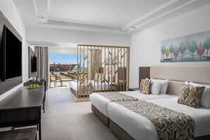 A modern hotel room with a large bed, a desk, and a view of the beach. - Albatros Makadi Resort (Makadi Bay)