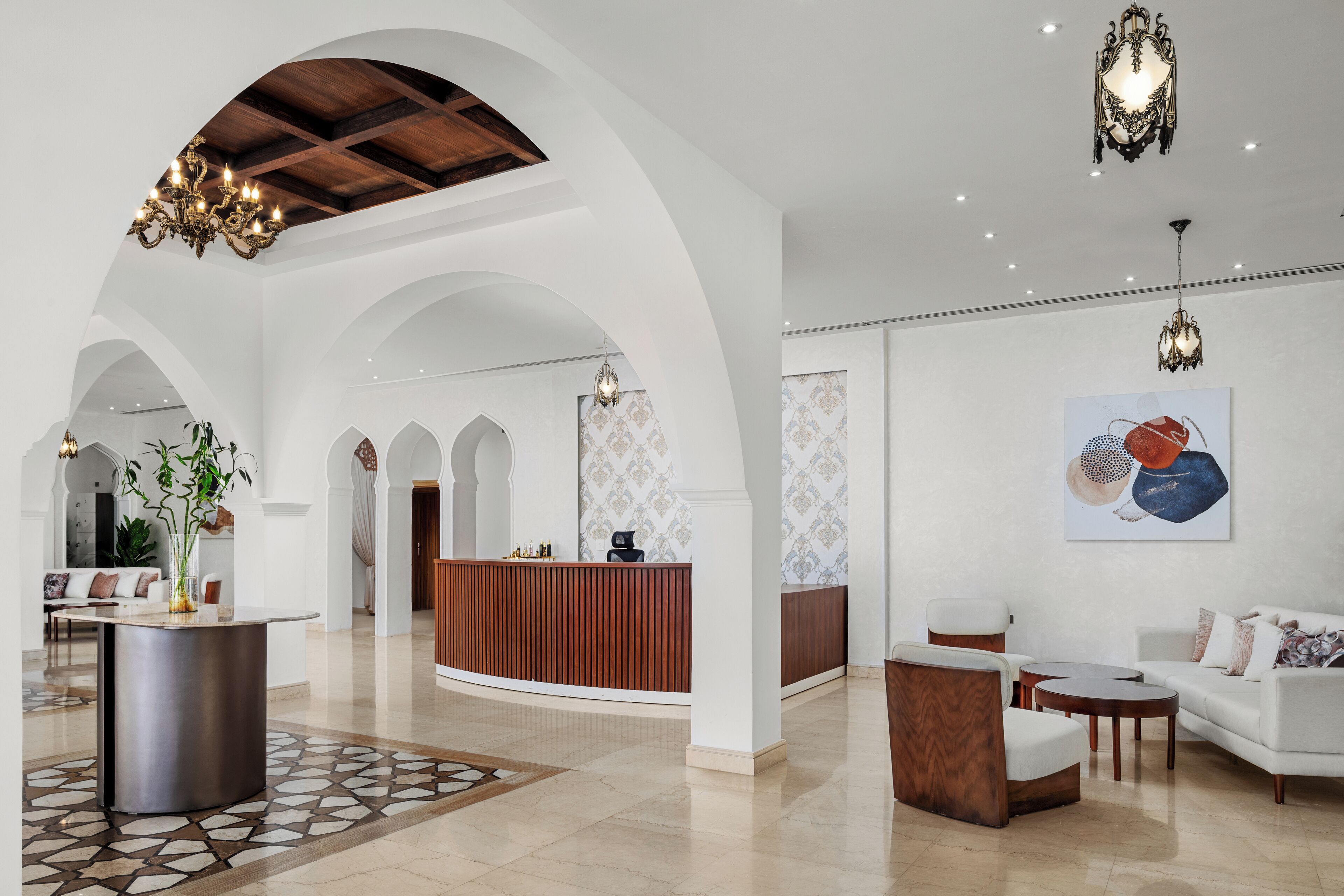 A spacious lobby with a reception desk, seating area, and decorative lighting.