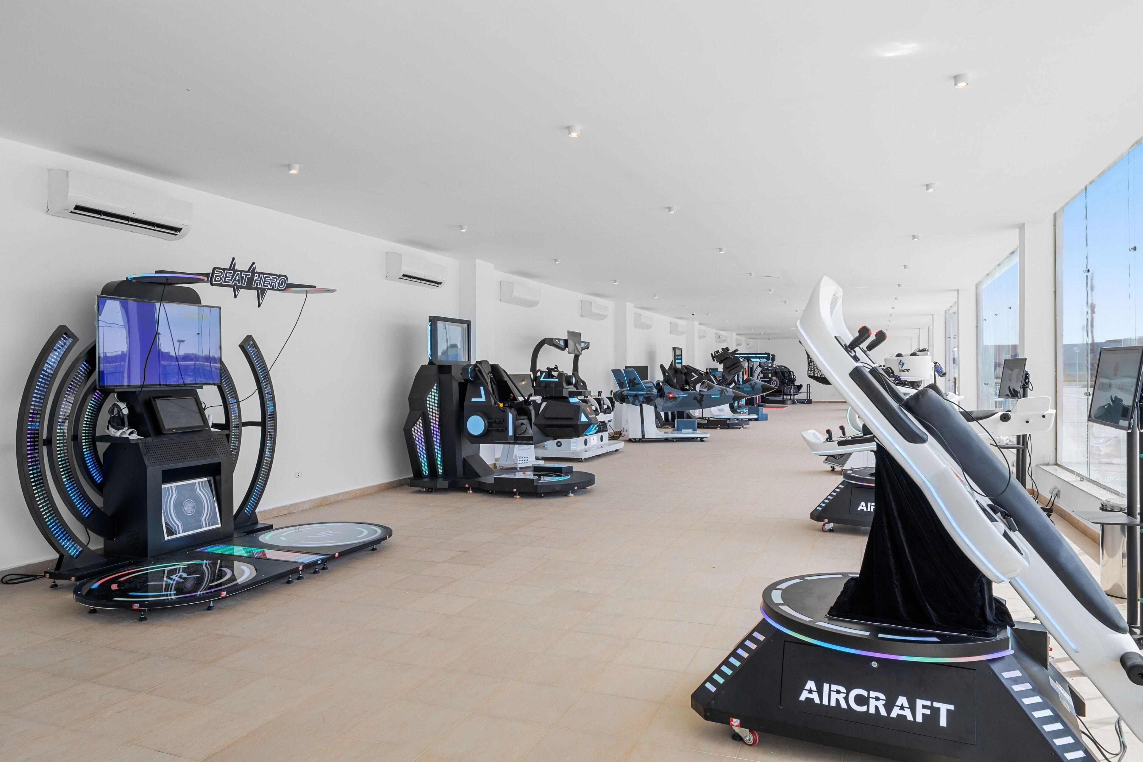 Et fitnesscenter med forskellige træningsmaskiner, herunder løbebånd og motionscykler, i en rummelig indretning.