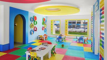 Ein helles Kinderzimmer mit kariertem Boden, Tischen, Stühlen und lehrreichen Wanddekorationen.
