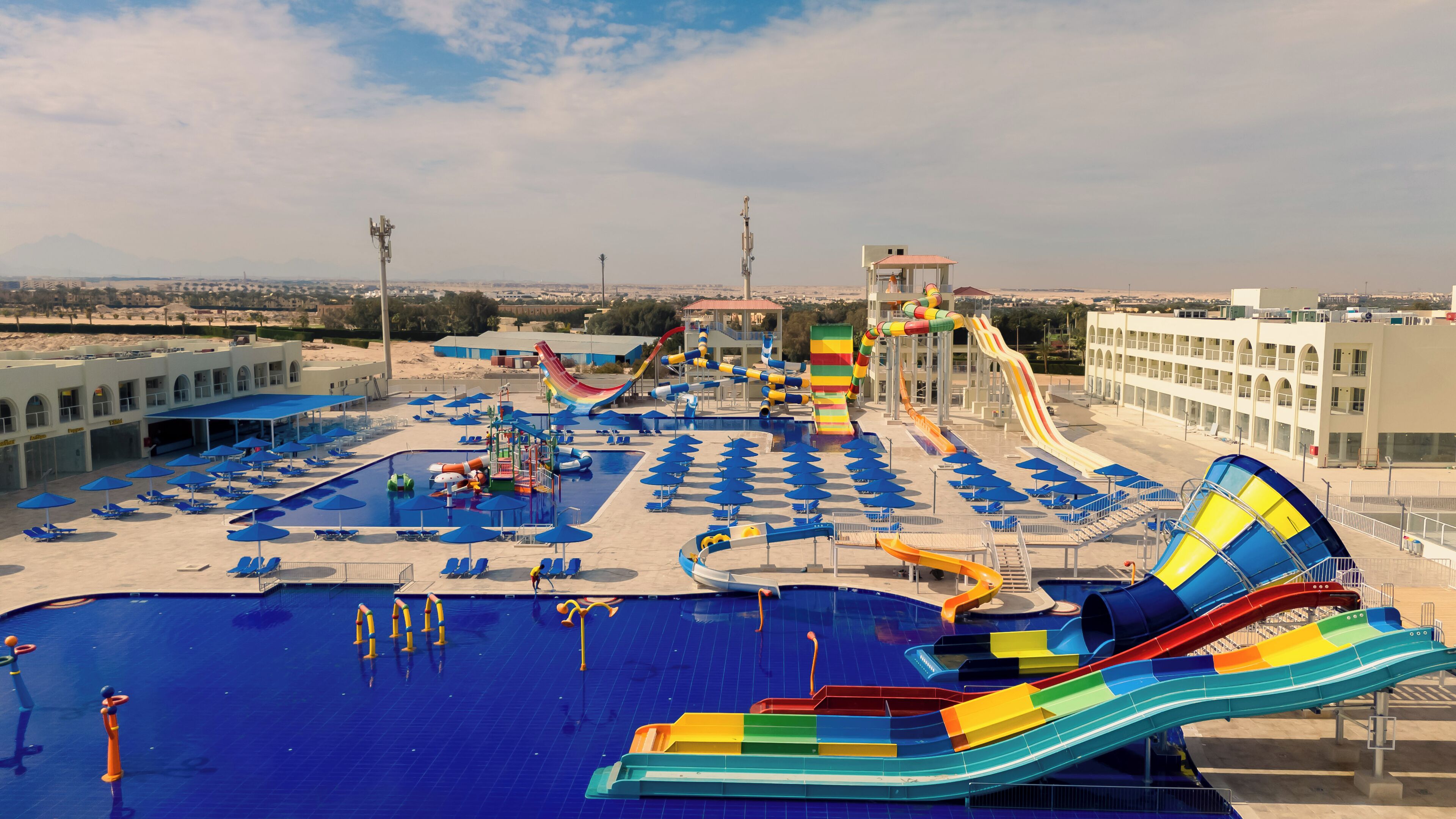 A water park with multiple slides, pools, and sun loungers.