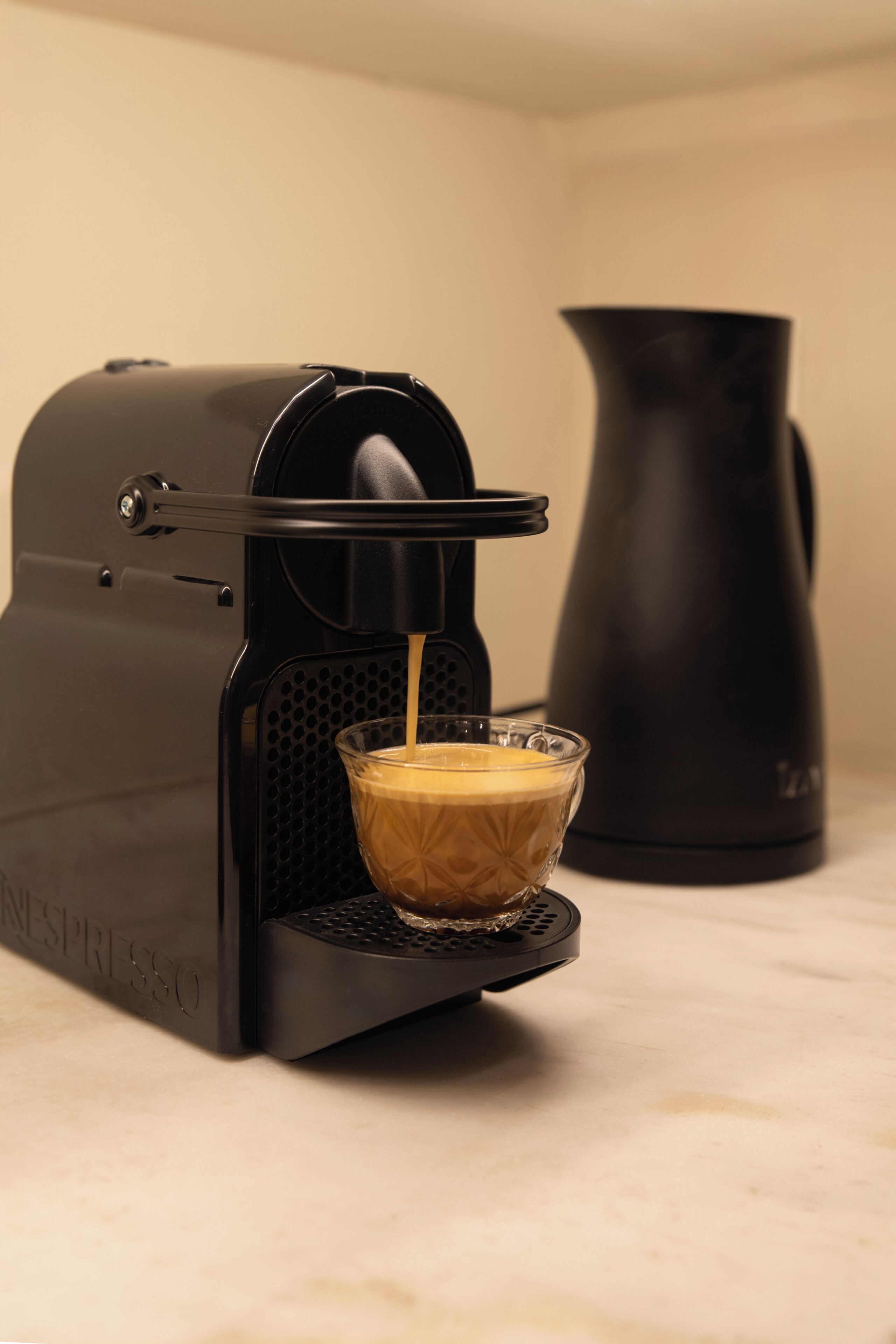 A coffee machine dispensing coffee into a glass cup.