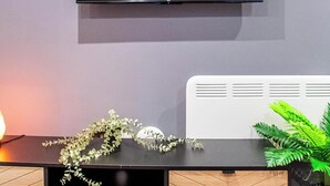 A modern living room with a flat-screen TV mounted on the wall displaying the Netflix logo. - Bradford City Apartment - Bolton Road Oasis (Bradford)