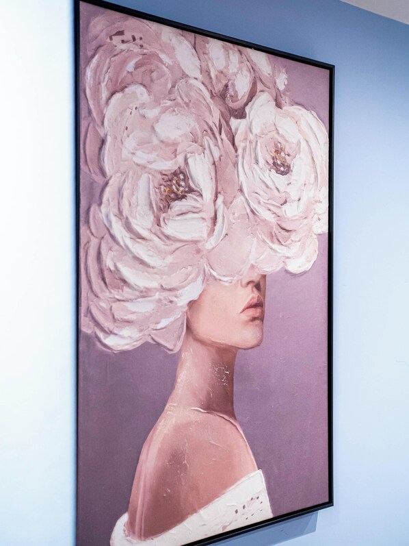 Una obra de arte enmarco que muestra a una mujer con una corona de flores.