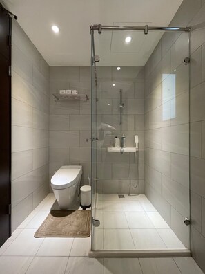 Un baño moderno con ducha de vidrio, inodoro y lavamanos.