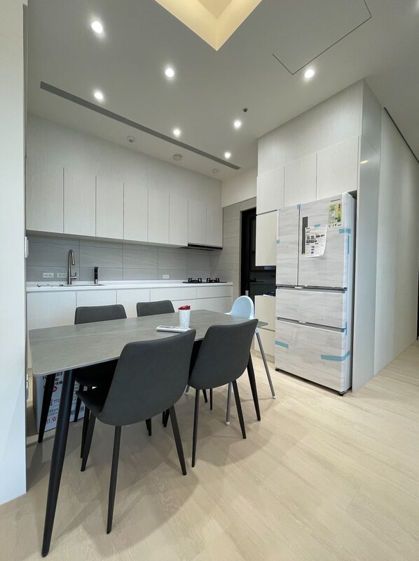 A modern kitchen with white cabinets, a grey countertop, and a built-in double refrigerator.