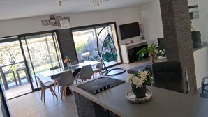 Una cocina moderna con comedor, ventanas amplias y televisor.