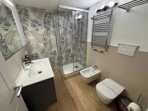 A modern bathroom with a glass shower, two sinks, a bidet, and a toilet. - Vatican Apartment D2 - 2 min. from the Valle Aurelia Metro Station, Wi-Fi, and air conditioning (Roma)