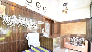 A reception area with a wooden reception desk, a reception sign, a waiting area with a sofa, and a wall with horse cutouts.