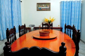 A dining table with chairs, a basket, and a vase with flowers. - Entire 1st Floor Alleppey Haven Homestay (Alappuzha)