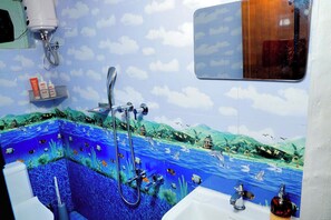 A bathroom with a mural of an underwater scene, a shower, and a sink with toiletries. - Entire 1st Floor Alleppey Haven Homestay (Alappuzha)