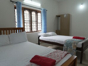 A room with two beds, a wardrobe, and a window with curtains. - Entire 1st Floor Alleppey Haven Homestay (Alappuzha)