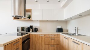 Eine moderne Küche mit Holzausstattung, Edelstahlgeräten und einer weißen Arbeitsplatte.