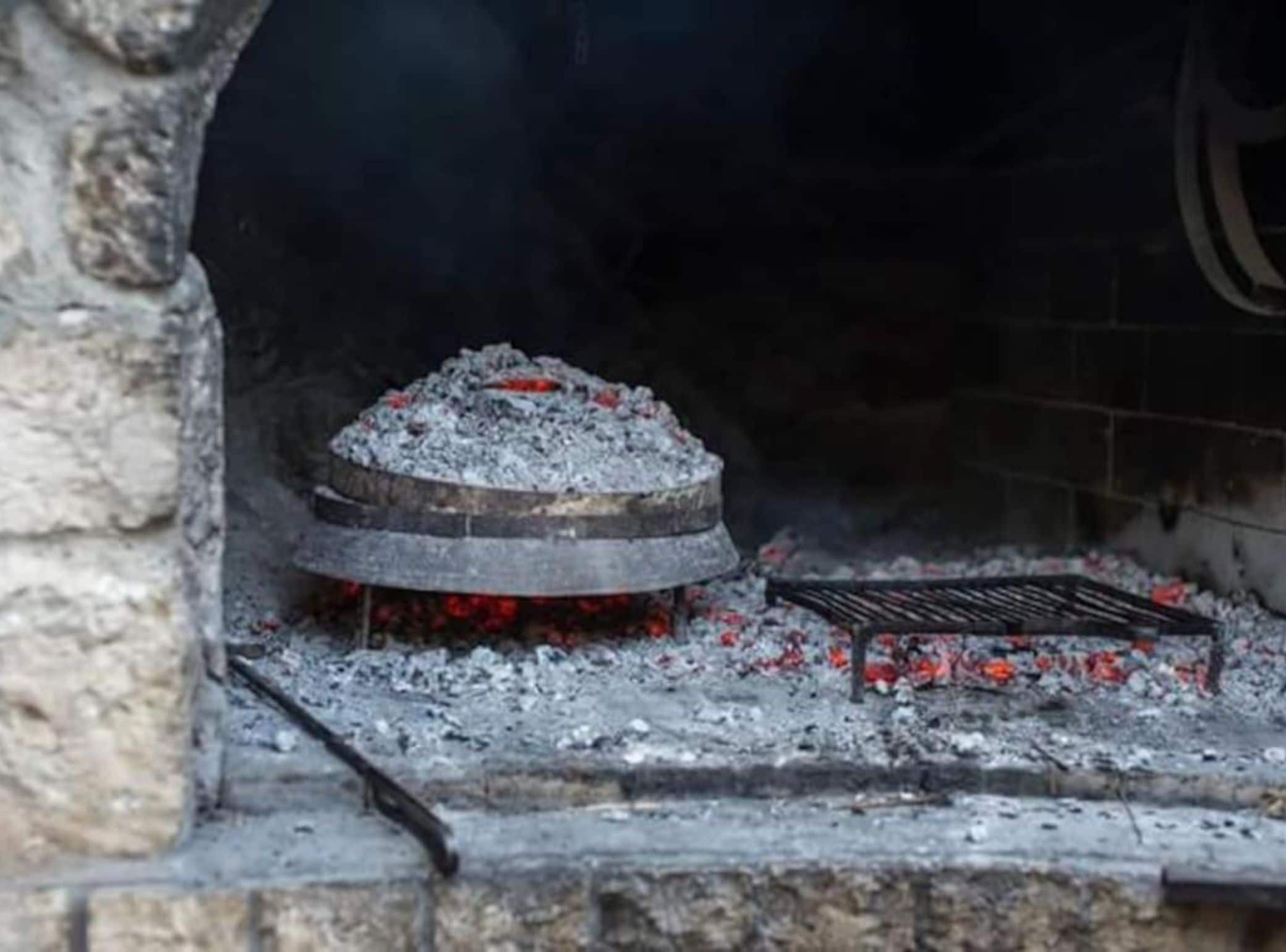 Una llar de pedra amb una banya circular i una reixeta.