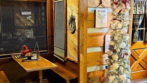 Une pièce chaleureuse avec un décor en bois, un sapin de Noël et un panneau indiquant «Il est interdit de fumer».