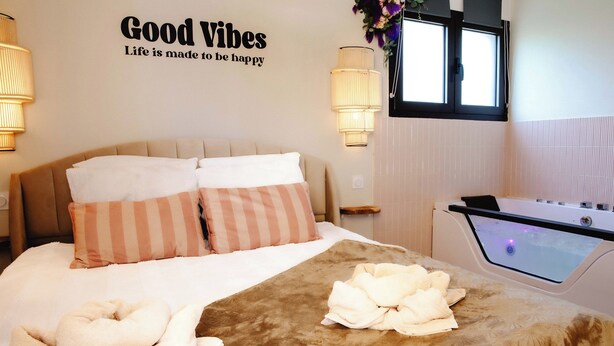 A hotel room with a bed, a massage table, and a wall with a motivational quote. - *Maison Castor* Balneo, pool and billiards! 10 minutes from the ocean! (Mimizan)