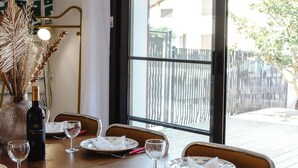 A dining table set for four with wine glasses, plates, and a bottle of wine. - *Maison Castor* Balneo, pool and billiards! 10 minutes from the ocean! (Mimizan)