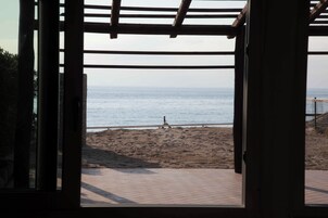 Une structure ouverte en bois offrant une vue sur une plage et l’océan.