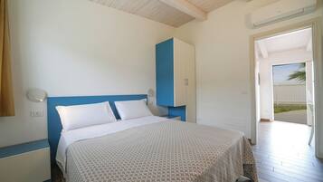 Un dormitorio con cama, armario y puerta que da a un espacio exterior.