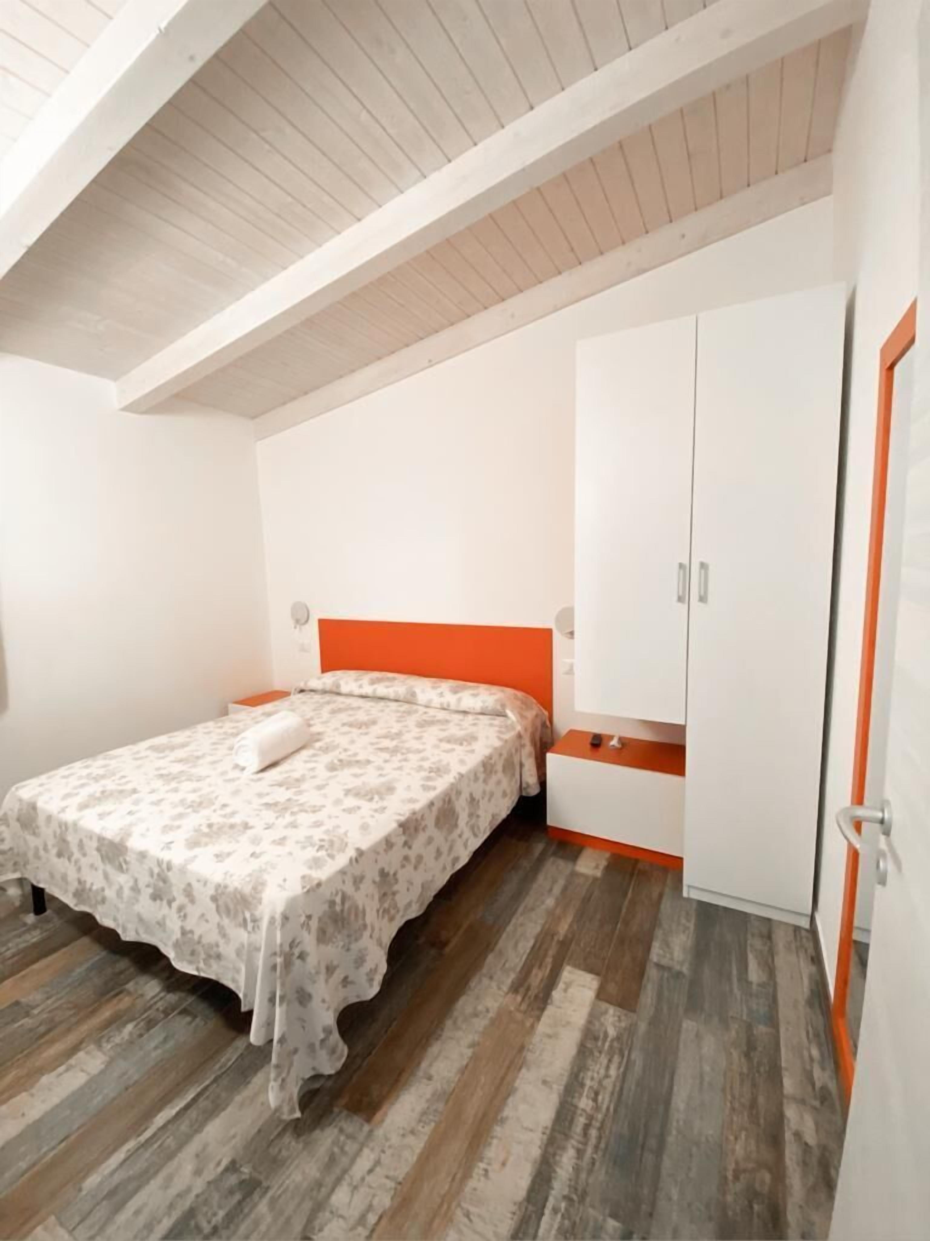 Une chambre à coucher avec un lit, une armoire et une porte.