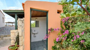 A bathroom with a sink and a window, surrounded by plants and flowers. - Galini villa, private pool , near amenities, Heraklion (Episkopi)