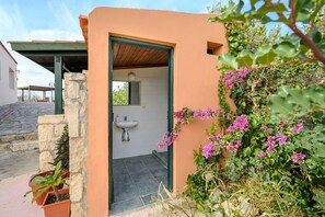 A bathroom with a sink and a window, surrounded by plants and flowers. - Galini villa, private pool , near amenities, Heraklion (Episkopi)