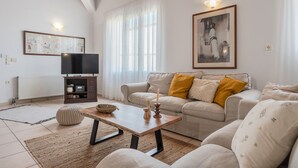 A living room with a sofa, a coffee table, a TV, and a framed picture on the wall. - Galini villa, private pool , near amenities, Heraklion (Episkopi)