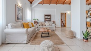 A spacious living room with a high wooden ceiling, a large bookshelf, and a cozy seating area with two sofas and a coffee table. - Galini villa, private pool , near amenities, Heraklion (Episkopi)