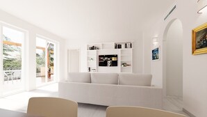 A modern living room with a white sofa, a dining table with chairs, and a bookshelf. - VILLA LEONARDO IN THE HEART OF POSITANO Central location (Positano)