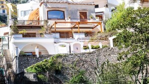 A coastal village with white buildings, stone walls, and a mountainous backdrop. - VILLA LEONARDO IN THE HEART OF POSITANO Central location (Positano)
