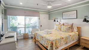 A bedroom with a bed, a desk, a chair, a window, and a ceiling fan. - 513 Sunsuite (Fripp Island)
