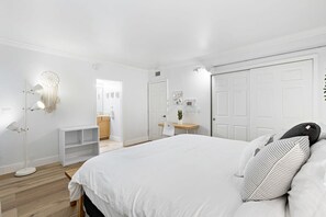 A bedroom with a large bed, a bedside table, a desk, and a wardrobe. - Charming Apartment in Las Olas Blvd Isle (Fort Lauderdale)