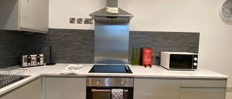 A modern kitchen with a stainless steel range hood, a built-in microwave, and a dishwasher.
