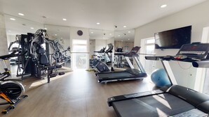A modern gym with various exercise equipment, including treadmills, elliptical machines, and weight machines. - Luxury Apartment - Town Centre North Stevenage (Stevenage)