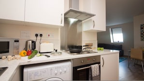 Una cucina compatta con forno a microonde, tostapane, piano cottura e lavastoviglie.