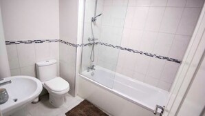 A bathroom with a toilet, sink, and bathtub.
