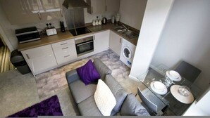 A compact kitchen with a built-in oven, microwave, and washing machine.