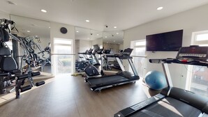 A gym with treadmills, exercise bikes, and weight machines.