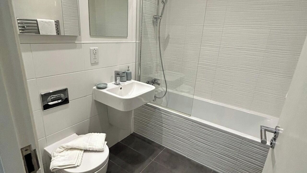 A small bathroom with a toilet, sink, and shower.