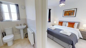 Une chambre d’hôtel moderne dotée d’une salle de bain comprenant des toilettes, un lavabo et un radiateur.