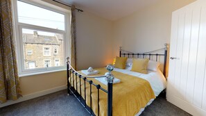 A bedroom with a bed, a window, and a door. - Stayzo Westminster Stylish House Accommodation (Bradford)