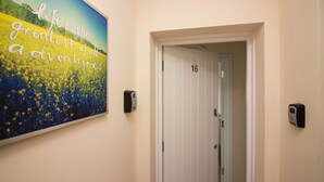 Un couloir avec une porte portant le numéro « 16 » et une citation inspirante affichée sur le mur.