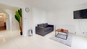 A modern living room with a grey sofa, a wooden coffee table, and a large plant. - Parlaunt House - 3 Bedroom With Free Parking (Slough)