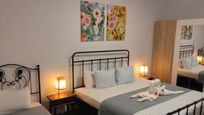 Ein Schlafzimmer mit einem Einzelbett, zwei Nachttischen und zwei an der Wand befestigten Bildern.
