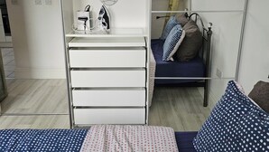 Une chambre à coucher avec un lit, une commode et un miroir.