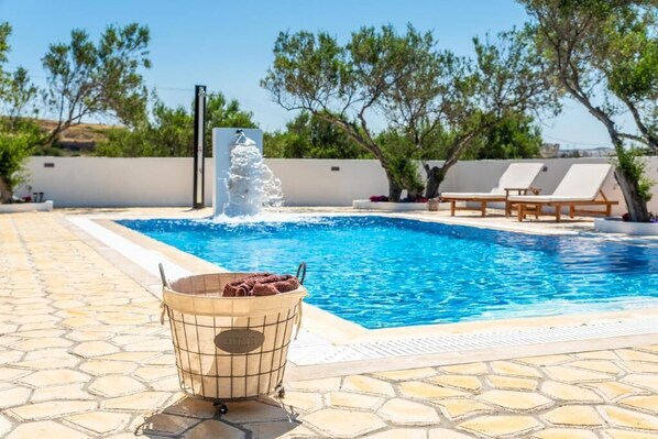 Una piscina al aire libre de temporada, sillones reclinables de piscina