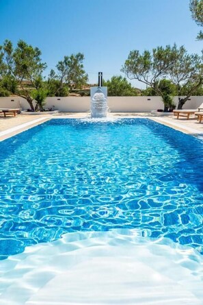 Una piscina al aire libre de temporada, sillones reclinables de piscina
